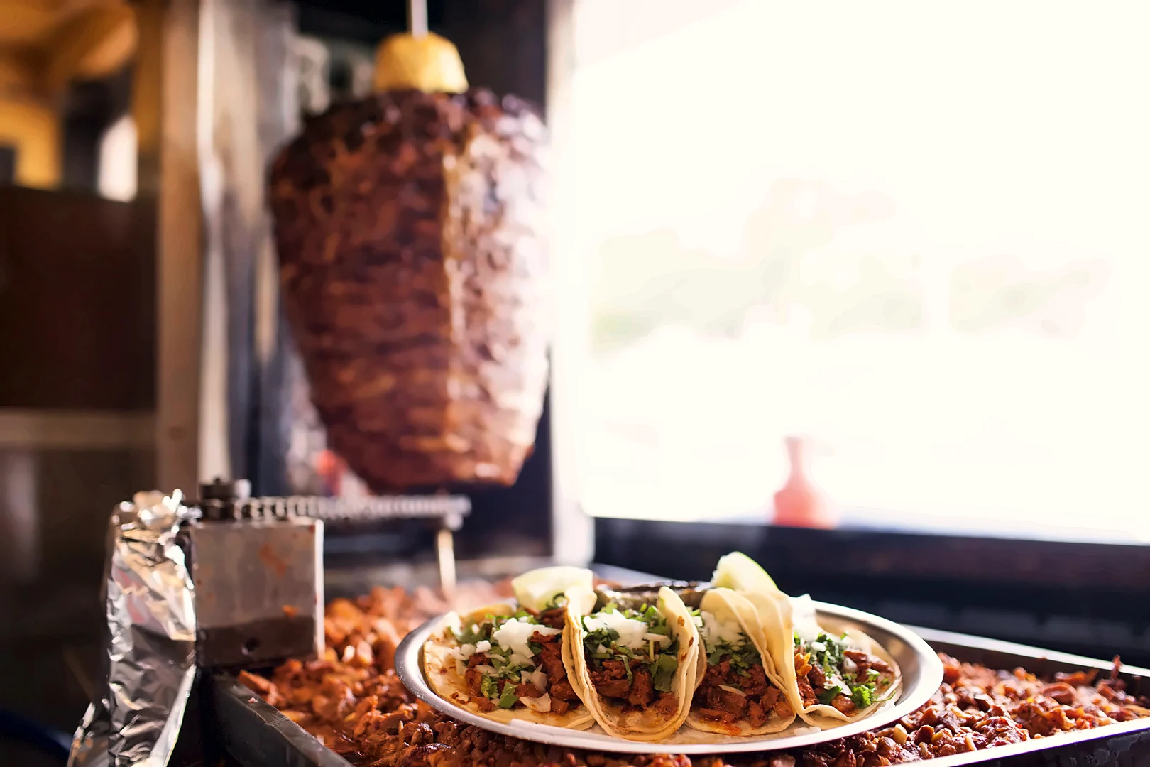 Tacos al pastor in front of the trompo at Taquería Del Sol